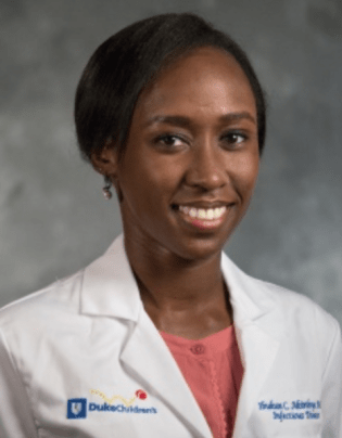 Young Black female in a white doctor's coat with Duke Health printed on it